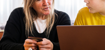 A mother and teen son shopping online at home