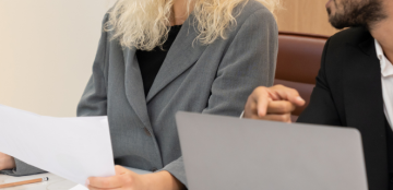 Corporate businesspeople using laptop discussing marketing project.