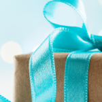 Christmas gift or present box against turquoise background.