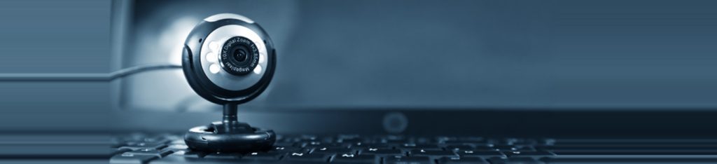 Close-up of a webcam positioned on a laptop keyboard.