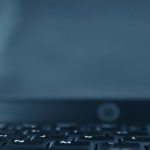 Close-up of a webcam positioned on a laptop keyboard.