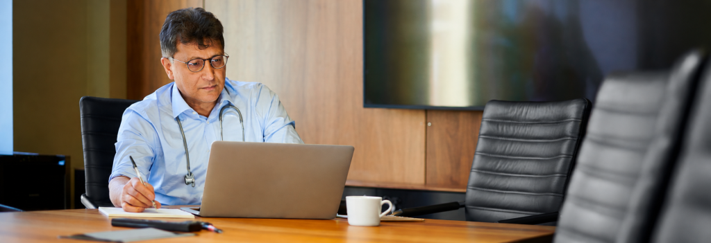 Doctor reviewing notes on laptop